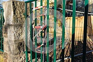 Fixing a construction hoarding to a fence using caution tape