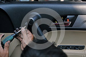 Fixing door`s car engine in automobile repair garage. Mechanics in uniform are repairing car