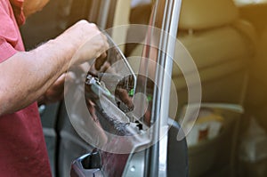 Fixing door`s car engine in automobile repair garage. Mechanics in uniform are repairing car