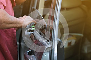 Fixing door`s car engine in automobile repair garage. Mechanics in uniform are repairing car