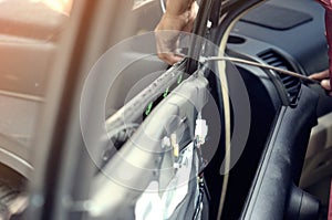 Fixing door`s car engine in automobile repair garage. Mechanics in uniform are repairing car