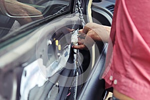 Fixing door`s car engine in automobile repair garage. Mechanics in uniform are repairing car