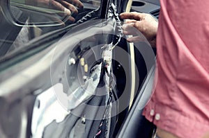 Fixing door`s car engine in automobile repair garage. Mechanics in uniform are repairing car