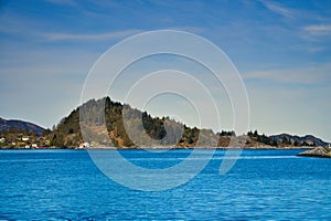 Fjord with mountains on horizon. Water glistens in the sun in Norway. Landscape