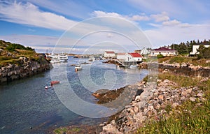 Fjord surrounded by buildings, boats moored