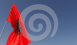 Flag of Albania on flagpole on blue background. Place for text. The flag is unfurling in wind. Europe, Tirana. Balkans. 3D