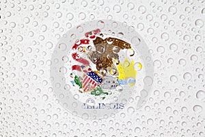 Flag of American State Illinois behind a glass covered with rain