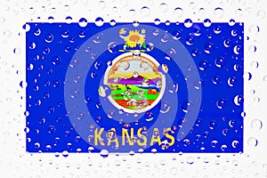 Flag of American State Kansas behind a glass covered with raindrops.