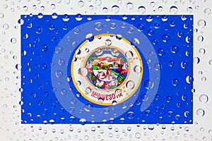 Flag of American State Minnesota behind a glass covered with raindrops