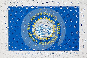 Flag of American State South Dakota behind a glass covered with