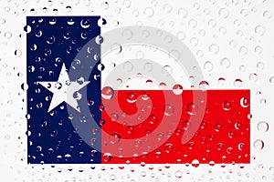 Flag of American State Texas behind a glass covered with rain dr