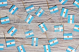 Flag of Argentina hanging on clothesline attached with wooden clothespins on aqua blue wooden background. National day concept photo