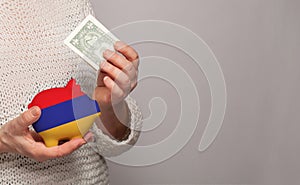 Flag of Armenia on money bank in Armenian woman hands. Dotations, pension fund, poverty, wealth, retirement concept