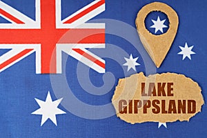 The flag of Australia has a geolocation symbol and a sign with the inscription - Lake Gippsland