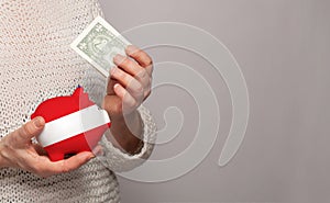 Flag of Austria on money bank in Austrian woman hands. Dotations, pension fund, poverty, wealth, retirement concept