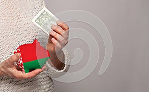 Flag of Belarus on money bank in Belarussian woman hands. Dotations, pension fund, poverty, wealth, retirement concept