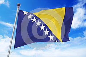 Flag of Bosnia and Herzegovina developing against a clear blue sky