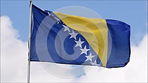 The flag of the Bosnia and Herzegovina waves in the wind in slow motion