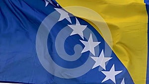 The flag of the Bosnia and Herzegovina waves in the wind in slow motion