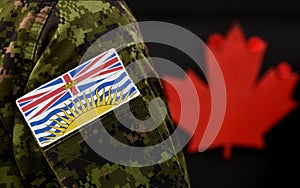 Flag of British Columbia on the military uniform and red Maple leaf on the background. Flag of Canadian province of British