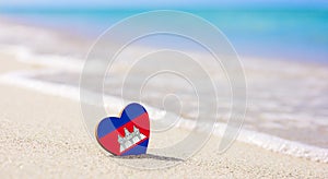 Flag of Cambodia in the shape of a heart on a sandy beach.