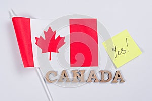Flag of Canada, word Canada in wooden abstract letters, sticker with the inscription yes.