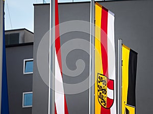 Flag of Carinthia, or Karntern, waiving in front of a flag of the city of Villach and a flag of Austria. Carinthia, or karnten