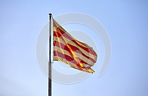 Flag of Catalonia against the blue sky.