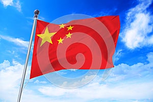 Flag of China developing against a blue sky