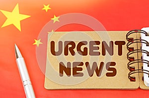 On the flag of China lies a notebook with the inscription - Urgent news