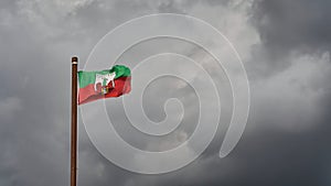 Flag with the city arms of Magdeburg in Germany in front of a gloomy sky