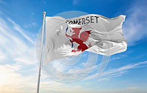 flag of county Somerset Unofficial , UK at cloudy sky background on sunset, panoramic view. County of united kingdom of great