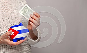 Flag of Cuba on money bank in Cuban woman hands. Dotations, pension fund, poverty, wealth, retirement concept