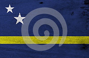 Flag of Curacao on wooden plate background. Grunge Curacao flag texture.