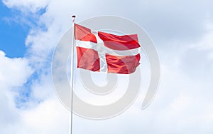 flag of denmark in a blue sky with clouds photo