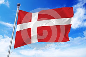 Flag of Denmark developing against a clear blue sky