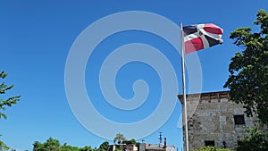 Flag of Dominican Republic waving in the wind against blue sky. Dominican flag