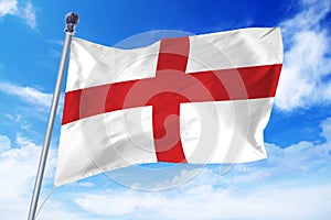 Flag of England developing against a clear blue sky