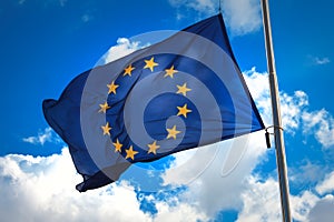 Flag of the European Union against a blue cloudy sky.
