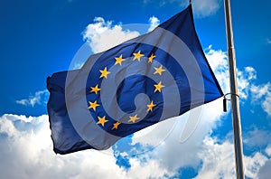 Flag of the European Union against a blue cloudy sky.