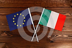 Flag of European Union and flag of Italy crossed with each other. The image illustrates the relationship between countries