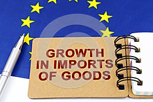 On the flag of the European Union lies a pen and a notepad with the inscription - growth in imports of goods