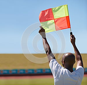 Flag, foul and man soccer referee in football match or game wave to stop play during sport training or workout. Hand