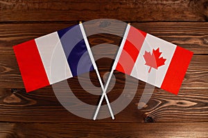 Flag of France and flag of Canada crossed with each other. The image illustrates the relationship between countries