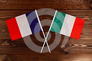 Flag of France and flag of Italy crossed with each other. The image illustrates the relationship between countries