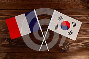 Flag of France and flag of South Korea crossed with each other. The image illustrates the relationship between countries