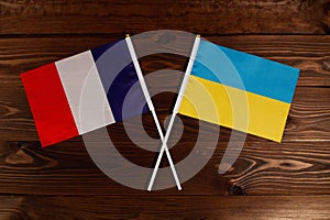 Flag of France and flag of Ukraine crossed with each other. The image illustrates the relationship between countries