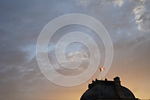 Flag of France at the top of Sully wing of Louvre Museum at dusk
