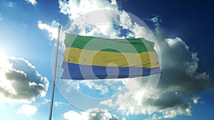 Flag of Gabon waving at wind against beautiful blue sky