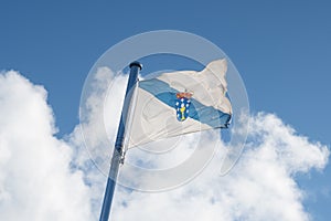 Flag of Galicia waving on the sky